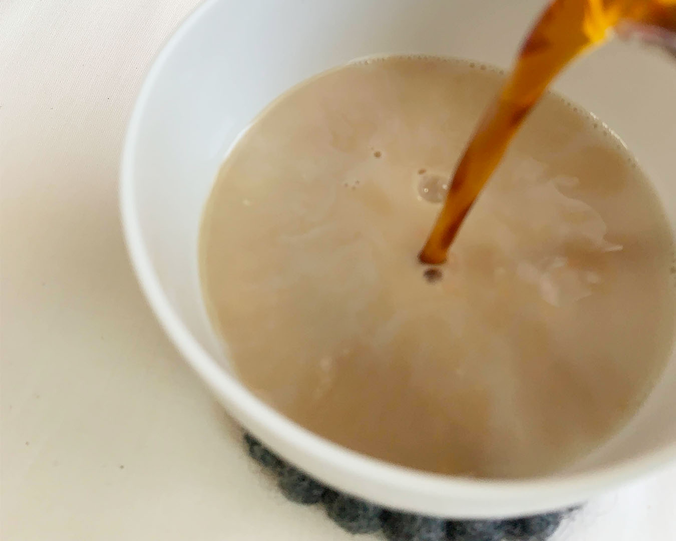 牛乳に紅茶液を注ぐ